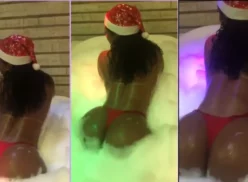 Vanessa Rodrigues, vestida de Papá Noel con gorro, bailando con su gran culo en la bañera llena de espuma