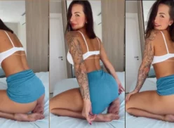 Karol Rosalin, musa de onlyfans, con falda corta dejando ver sus bragas mientras está acostada en la cama