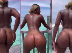 Negra luciendo bailando sensualmente con el culo expuesto en una playa